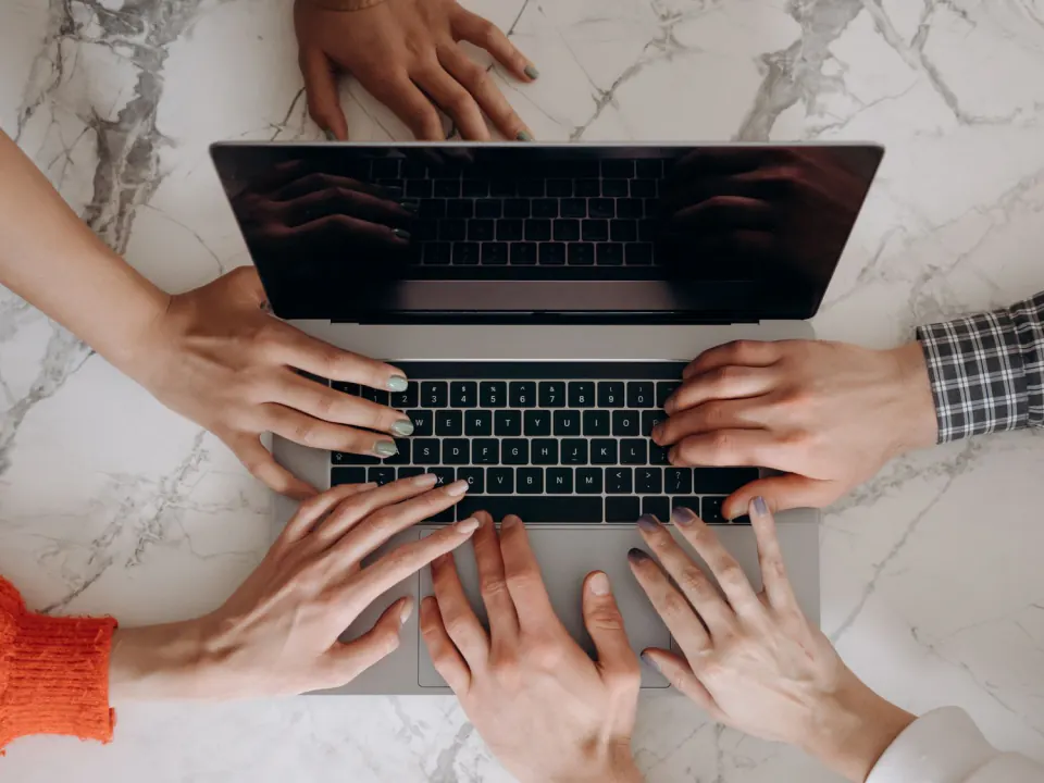 Several people working together on one laptop